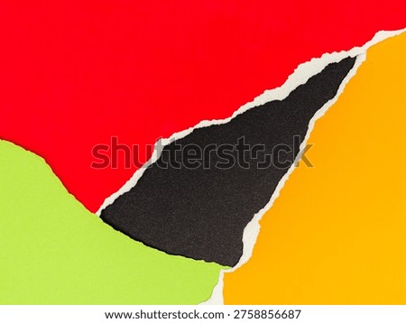 bstract background featuring overlapping and torn pieces of red, yellow, and green paper over a black textured background.