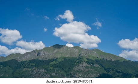 bstract mountain landscape with sharp peaks under bright blue sky with clouds. Minimalist nature background.