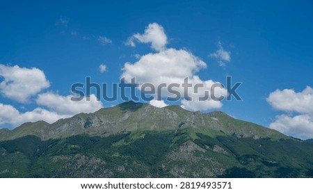 bstract mountain landscape with sharp peaks under bright blue sky with clouds. Minimalist nature background.