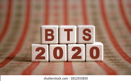 BTS 2020 text on wooden cubes on a monochrome background with reflection.