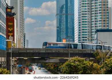 BTS Skytrain, Electric train, running on the way with business office buildings on the background.
