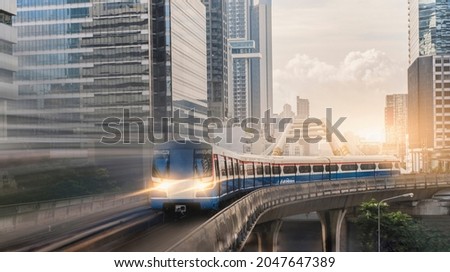BTS Skytrain, Electric train, running on the way with business office buildings on the background.
