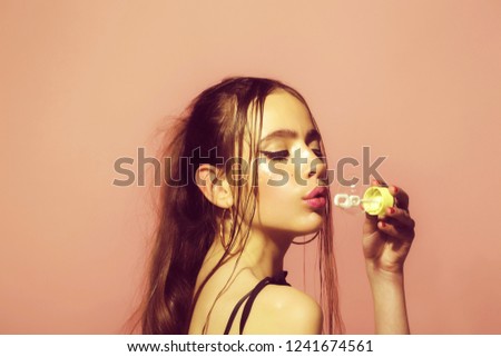 Bubble blower in hand of fashion model. Woman play with soap balloon. Girl with glamour makeup and hair. Fun and joy. Beauty and fashion.