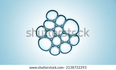 Bubble cluster of twelve bubbles against cyan background macro shot | Shot of skin care cream ingredients for skin hydration concept