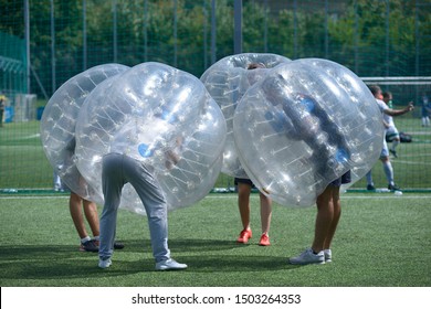 Bubble football. People in bubble inside putting heads together before a game