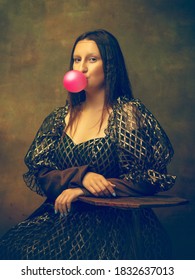 Bubble Gum. Young Woman As Mona Lisa, La Gioconda Isolated On Dark Green Background. Retro Style, Comparison Of Eras Concept. Beautiful Female Model Like Classic Historical Character, Old-fashioned.