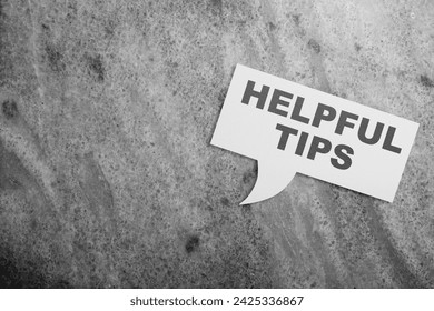 Bubble speech with 'Helpful tips' text on a black background. Tips and advice concept