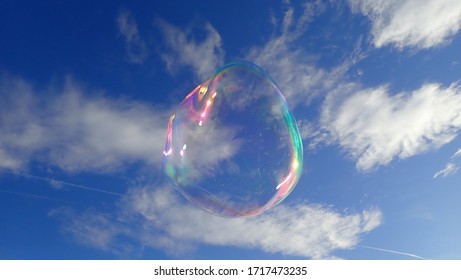 
eine Blase mit tausend Farbreflektionen fliegt in einem blauen Himmel