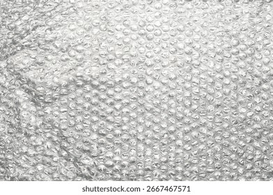 Bubble wrap packaging material with transparent plastic surface and air-filled bubbles, isolated background texture for protection, shipping, storage, moving, and wrapping.