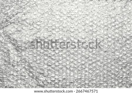 Bubble wrap packaging material with transparent plastic surface and air-filled bubbles, isolated background texture for protection, shipping, storage, moving, and wrapping.