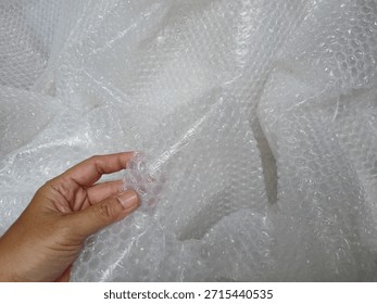 Bubble wrap, a pliable transparent plastic material for protecting fragile items during shipping.