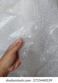 Bubble wrap, a pliable transparent plastic material for protecting fragile items during shipping.