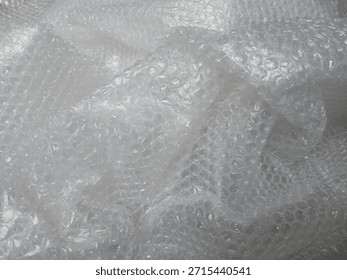 Bubble wrap, a pliable transparent plastic material for protecting fragile items during shipping.