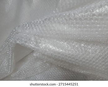 Bubble wrap, a pliable transparent plastic material for protecting fragile items during shipping.