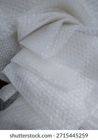 Bubble wrap, a pliable transparent plastic material for protecting fragile items during shipping.