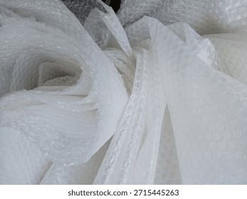 Bubble wrap, a pliable transparent plastic material for protecting fragile items during shipping.