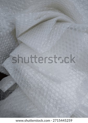 Bubble wrap, a pliable transparent plastic material for protecting fragile items during shipping.