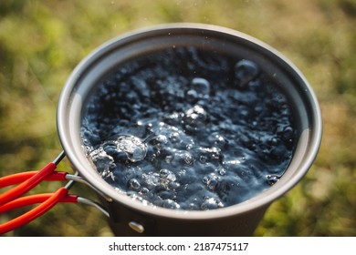 Bubbles Of Boiling Water In A Pot, Warm Water For Tea, Bubbling Liquid, Camp Utensils For Cooking, Top View Of The Water. High Quality Photo