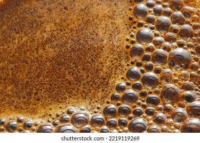 Bubbles of coffee foam close-up. Selective focus. The texture of the coffee foam of freshly brewed aromatic coffee. Food background.