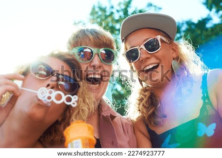Bubbles are fun at every age. a group of young women having fun blowing bubbles.