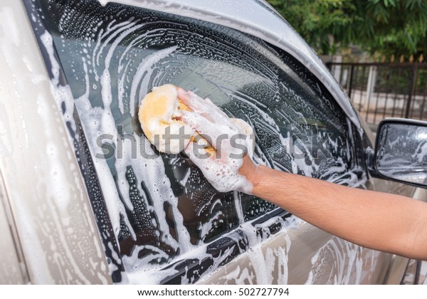 Bubbles, Man\
hand with yellow sponge washing\
car.