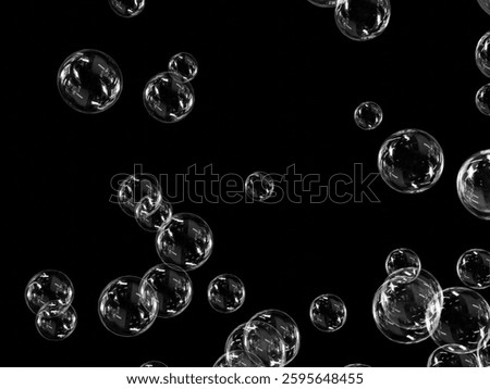Bubbles with reflections floating in the air on a black background.