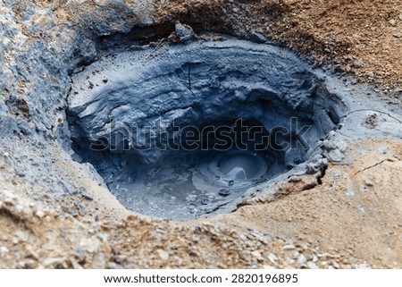 Bubbling mudpot with thick gray clay in an active geothermal volcanic area.