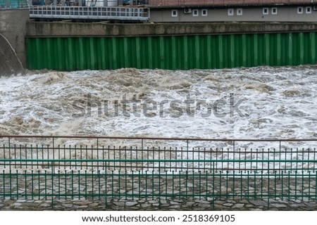 Bubbling river with a large current at flood time. Concept water management, and infrastructure resilience during extreme weather conditions. High quality photo