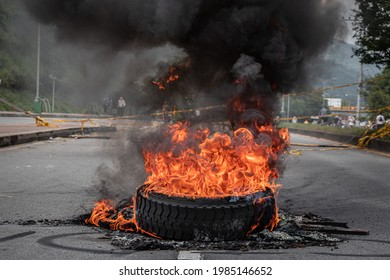 Bucaramanga, Colombia; 05 28 2021: Protesters Fire Tire Car On Street With Smoke Horizontal Banner