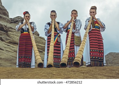 Bucegi Mountains, Romania - August 6, 2016: Group of Romanian female tulnic players dressed in colorful traditional costumes on Bucegi mountains plateau near the legendary Sphinx megalith.