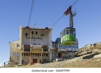 BUCEGI, ROMANIA - OCTOBER 10, 2015: Green cable car arrives at Babele station, transporting tourists from Busteni resort across Bucegi Mountains plateau, Southern Carpathians, Romania.