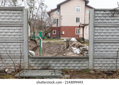 BUCHA, UKRAINE - Apr. 03, 2022: People buried their dead relatives and neighbors in the yards during the occupation. In the yards of Bucha there are a lot of wooden crosses knocked down alone.