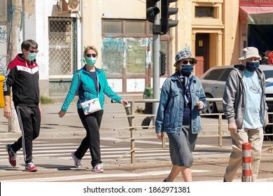 Bucharest, Romania - 04 27 2020: People With Face Masks Crossing The Street During Pandemic