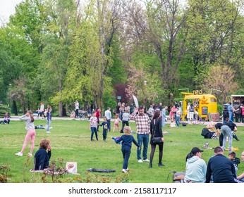 Bucharest, Romania - 04.15.2022: People relaxing and having fun on the grass in KIng MIhai I park (Herestrau), in Bucharest