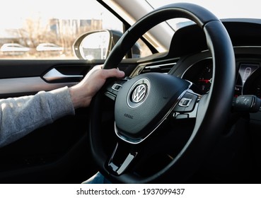 Bucharest, Romania 11.03.2021.Volkswagen Passat B8.Man holding a steering wheel. Steering wheel details and steering wheel controls. Leather-wrapped Steering wheel. VW emblem seen up close.