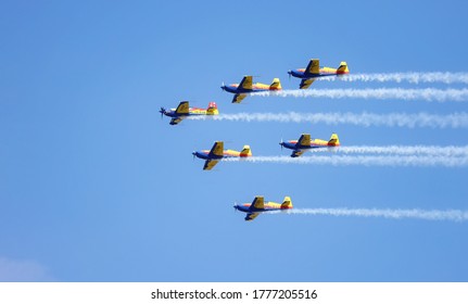 Bucharest, Romania - 16 Jul 2020: Airshow with planes performing acrobatic flight on blue sky. Trace of Smoke behind. Hawks of Romania team of the Romanian Aeroclub with 6 Extra Flugzeugbau EA 300