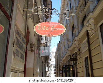 Bucharest, Romania - April 20, 2011: Narrow Retro Street With Old Buildings And Multiple Commercial Building Signs.