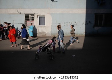 Bucharest, Romania - April 21, 2016: People On The Street Near Worn Out Blocks Of Flats In A Poor Neighborhood In Bucharest.