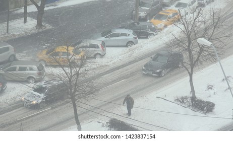 BUCHAREST - ROMANIA, CIRCA JANUARY 2019, 4K Traffic car street in heavy snow fall, pedestrian people cross road in blizzard