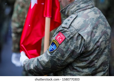 Bucharest, Romania - December 01, 2019: Details Of A Turkish Army Soldier Holding A Flag And Having Turkey And NATO Insignia. Turkey And NATO Relationship.