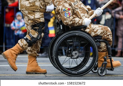 Bucharest, Romania - December 01, 2019: Romanian army veteran soldiers, injured and disabled (one sitting in a wheelchair) take part at the Romanian National Day military parade.