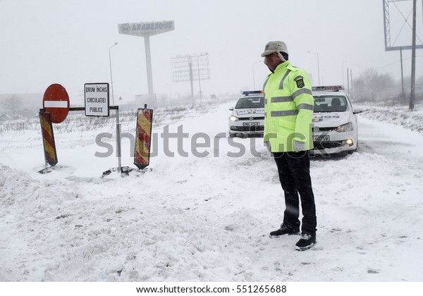 BUCHAREST, ROMANIA - January 06, 2017: A\
police car blocks the access on A2 motorway to the main harbor of\
Black Sea, Constanta, due to the snow\
storm.