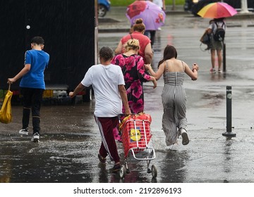 Bucharest, Romania - June 17, 2022: People Cross The Street During Heavy Rain.