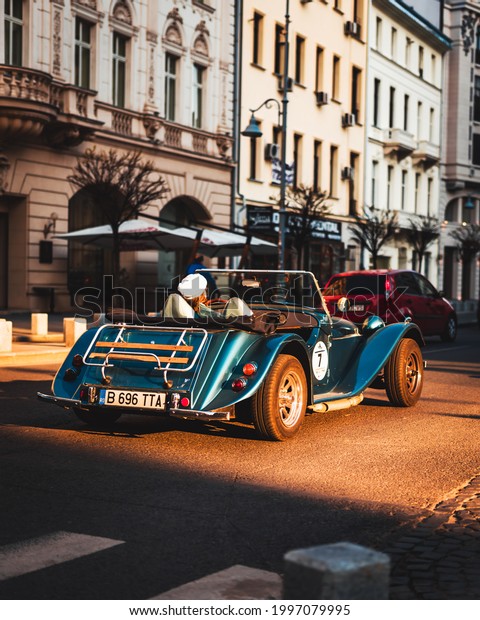 Bucharest,\
Romania - June 25 2021: Photography of a lady driving her Morgan\
vehicle on Calea Victoriei during\
sunset