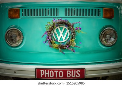 Bucharest, Romania - June 5, 2019

A turquoise Volkswagen photo bus with lavender wreath on the symbol logo.
