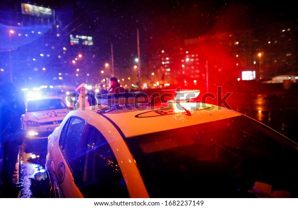 Bucharest, Romania - March 23, 2020: Police\
check out drivers and their papers during the curfew in the streets\
of Bucharest amid the spread of the\
COVID-19.