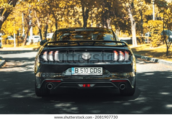 Bucharest, Romania - May 20 2021: Ford Mustang\
Ecoboost black coupe with spoiler rear view, stop lights, wheel and\
exhaust details