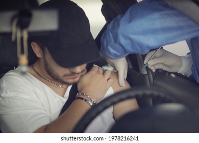 Bucharest, Romania - May 22, 2021: A Man Is Getting Covid-19 Vaccine In His Arm In His Car, In A Drive Thru Vaccination Centre In Bucharest, Romania.