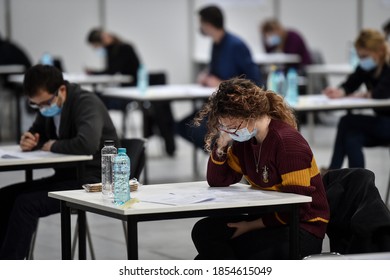 BUCHAREST, ROMANIA - NOVEMBER 15, 2020: Large number of students sustaining a written exam indoors of a huge hall respecting the social distance measure imposed by corona virus.