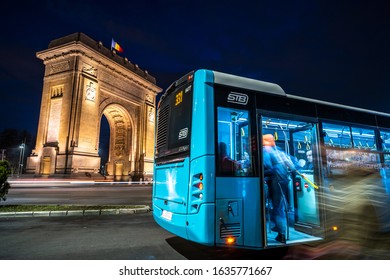 Bucharest, Romania-February 14th 2020:The Arch Of Triumph, Triumph Arch. Night Traffic In Front Of The Triumphal Arch. People Getting On The Bus. Bucharest Transport Service. Long Exposure Photography